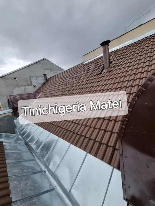 Jgheab din tablă și țiglă maro, pe o casă înaltă